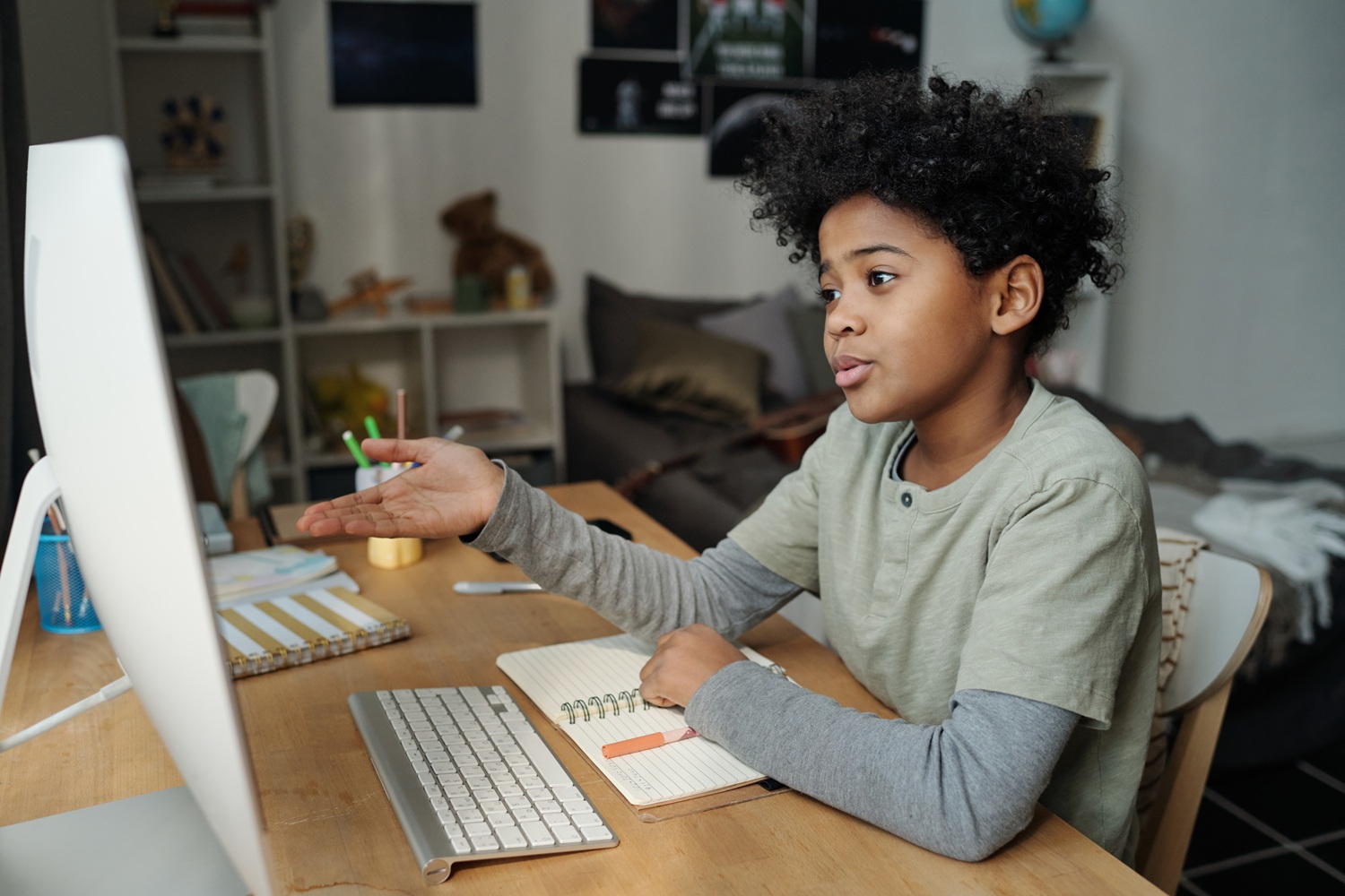 Cute schoolboy explaining something during online communication